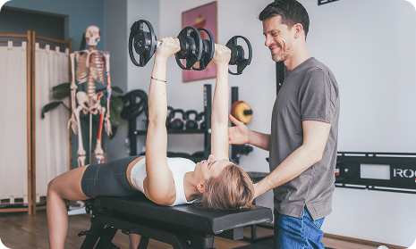 Daniel hilft Patientin mit heben von Gewichten